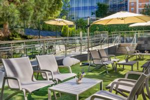 a row of chairs and tables with umbrellas at NH Madrid Ribera del Manzanares in Madrid