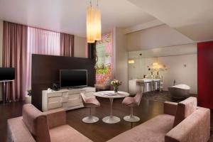 a living room with a television and a table and chairs at Nhow Milan in Milan