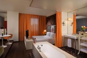 a hotel room with a bed and a bath tub at Nhow Milan in Milan