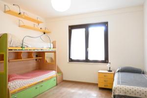 ein Schlafzimmer mit zwei Etagenbetten und einem Fenster in der Unterkunft SE160 - Senigallia, comodo trilocale con patio in Senigallia
