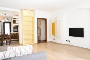 ein Wohnzimmer mit einem Sofa und einem Fernseher an der Wand in der Unterkunft SE160 - Senigallia, comodo trilocale con patio in Senigallia