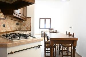 eine Küche mit einem Herd und einem Holztisch in der Unterkunft SE160 - Senigallia, comodo trilocale con patio in Senigallia