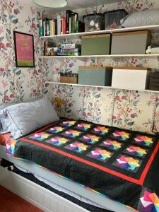 ein Schlafzimmer mit einem Bett mit einer bunten Decke darauf in der Unterkunft Cosy cottage in Snowdonia hamlet in Frongoch