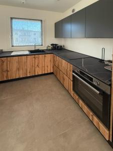 a kitchen with black counter tops and wooden cabinets at Valpo Living in San Pietro in Cariano +9 photos