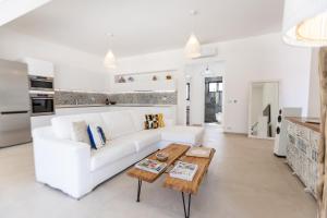 a living room with a white couch and a coffee table at Dimora Jolie Puglia in San Vito dei Normanni