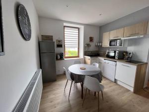 eine Küche mit Tisch und Stühlen in einem Zimmer in der Unterkunft Gite La Glycine, Moderne Tres Propre 3 Lits in Soultz-Haut-Rhin
