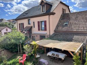 ein Haus mit einem Tisch und Stühlen davor in der Unterkunft Gite La Glycine, Moderne Tres Propre 3 Lits in Soultz-Haut-Rhin