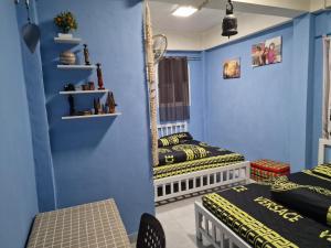 two twin beds in a room with blue walls at Jay Jay Guesthouse in Bangkok