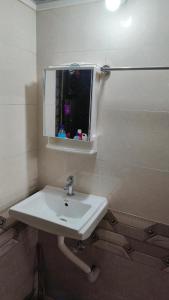 a bathroom with a white sink and a mirror at Rukhmini Niwas in Pural