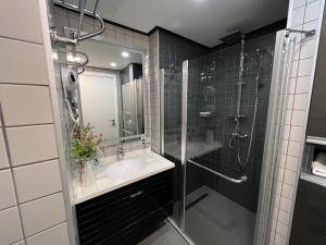 a bathroom with a sink and a shower with a glass door at alliance panorama Batumi in Batumi +26 photos