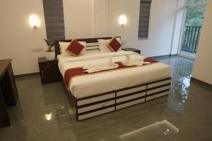 a bedroom with a bed with towels on it at Elenji Merry Woods Resort, Munnar, ##SWIMMING POOL## in Munnar +6 photos