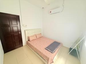 a small bedroom with a small bed with two pillows at Salahuddin Islamic Homestay Beserah Kuantan in Kuantan