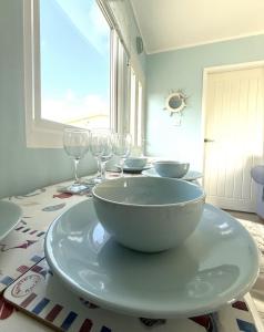 een tafel met glazen en een kom op een bord bij Carol's Chalet in Bridlington
