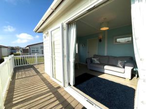 een veranda met een bank op een balkon bij Carol's Chalet in Bridlington