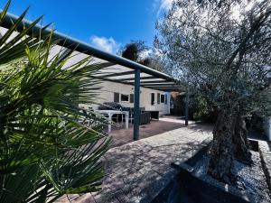 eine Terrasse mit einem Tisch und einem Baum in der Unterkunft RBR 655 - Beach Resort Kamperland in Kamperland
