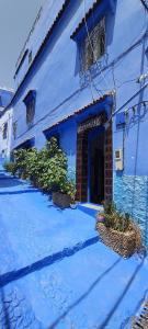 a blue building with a door in the middle at aline hostel 2 in Chefchaouen