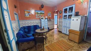 a living room with a blue couch and a refrigerator at aline hostel 2 in Chefchaouen