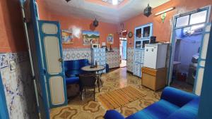 a kitchen with orange walls and blue furniture in a room at hostel in Chefchaouene