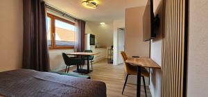 una camera da letto con un letto, un tavolo e una cucina di Elodia Luxus Apartment - WLAN, Magenta TV, Terrasse, Küche, Babybett a Heidenheim an der Brenz