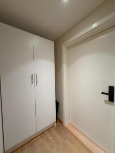 a white closet with a door in a room at PP1b-Central-Cosy studio flat Suits globetrotters in Oslo