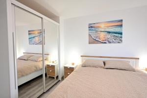 a bedroom with a large mirror and a bed at El sonido del mar in Puerto de Sagunto