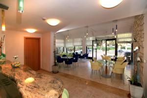 a restaurant with tables and chairs in a room at Hotel Flores in Poreč