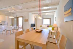 - une salle à manger et un salon avec une table et des chaises dans l'établissement Villa Castalia by Thalassa Residence Mykonos, à Plage d'Élia