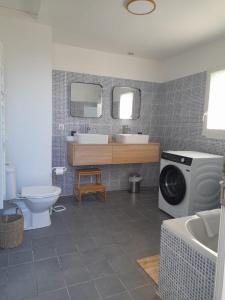 Maison de famille au cœur du bocage normand في Besneville: حمام مع مغسلة وغسالة ملابس