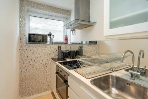 eine Küche mit Spüle und Herd oberen Backofen in der Unterkunft Marylebone Apartments by Sleepy Lodge London in London