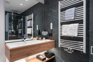 a bathroom with a sink and a large mirror at Rauriserhof 4 Sterne Superior in Rauris