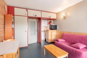 a living room with a pink couch and a table at Gourette - Au pieds des pistes in Eaux-Bonnes +16 photos