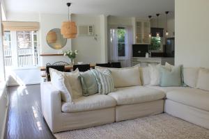 a living room with a white couch with pillows at Casa thirty-six, 3BR, Central Location in Tanunda