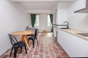 una cucina e un soggiorno con tavolo e sedie di L'appartement du centre - Hypercentre - Lavaur a Lavaur