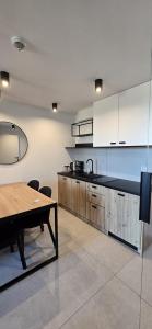 a kitchen with white cabinets and a wooden table at Green Port Spa&Wellness Rent Partners in Kołobrzeg