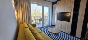 a living room with a couch and a flat screen tv at Green Port Spa&Wellness Rent Partners in Kołobrzeg