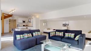 a living room with two blue couches and a kitchen at Le Chalet avec Piscine - Obernai in Obernai