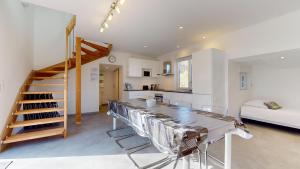 a kitchen and living room with a table and a staircase at Le Chalet avec Piscine - Obernai in Obernai