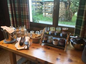 a wooden table with jars and baskets of food on it at Au Refuge de Blanche in Verchères