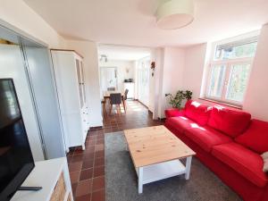 a living room with a red couch and a table at Kuckucksnest - Ferienwohnung mit Traumblick im Schwarzwald in Bad Wildbad