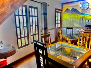 a room with a table and chairs and a painting at Niros Homestay Nuwara eliya in Nuwara Eliya