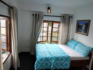 a bedroom with a bed and a window at Niros Homestay Nuwara eliya in Nuwara Eliya