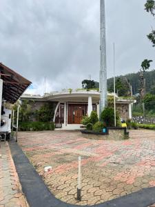 a house with a brick driveway in front of it at Niros Homestay Nuwara eliya in Nuwara Eliya