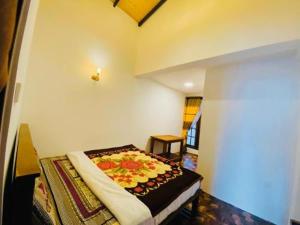a room with a bed with a flower blanket on it at Niros Homestay Nuwara eliya in Nuwara Eliya +8 photos