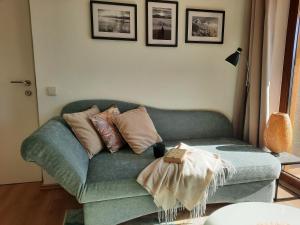 ein Wohnzimmer mit einer grünen Couch und Kissen in der Unterkunft Inspiration - zwei Terrassen, Seeblick, privater Garten in Altmünster + 48 Fotos