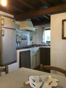 a kitchen with a table and a refrigerator at Chalet fronte piscina in Zambra