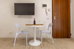 a white table with two chairs and a bottle of wine at 4 Twins - Central Room in Bari