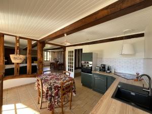 a kitchen and dining room with a table in a room at Gite maison campagne in Lavazan