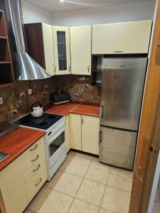 a kitchen with white cabinets and a stainless steel refrigerator at Apartament Mieszkanie Kamień Pomorski in Kamień Pomorski