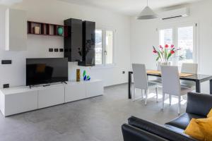 a living room with a television and a dining room table at VivimiHome - Monti House in Monti