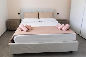 a large bed with two pink pillows on it at VivimiHome - Monti House in Monti